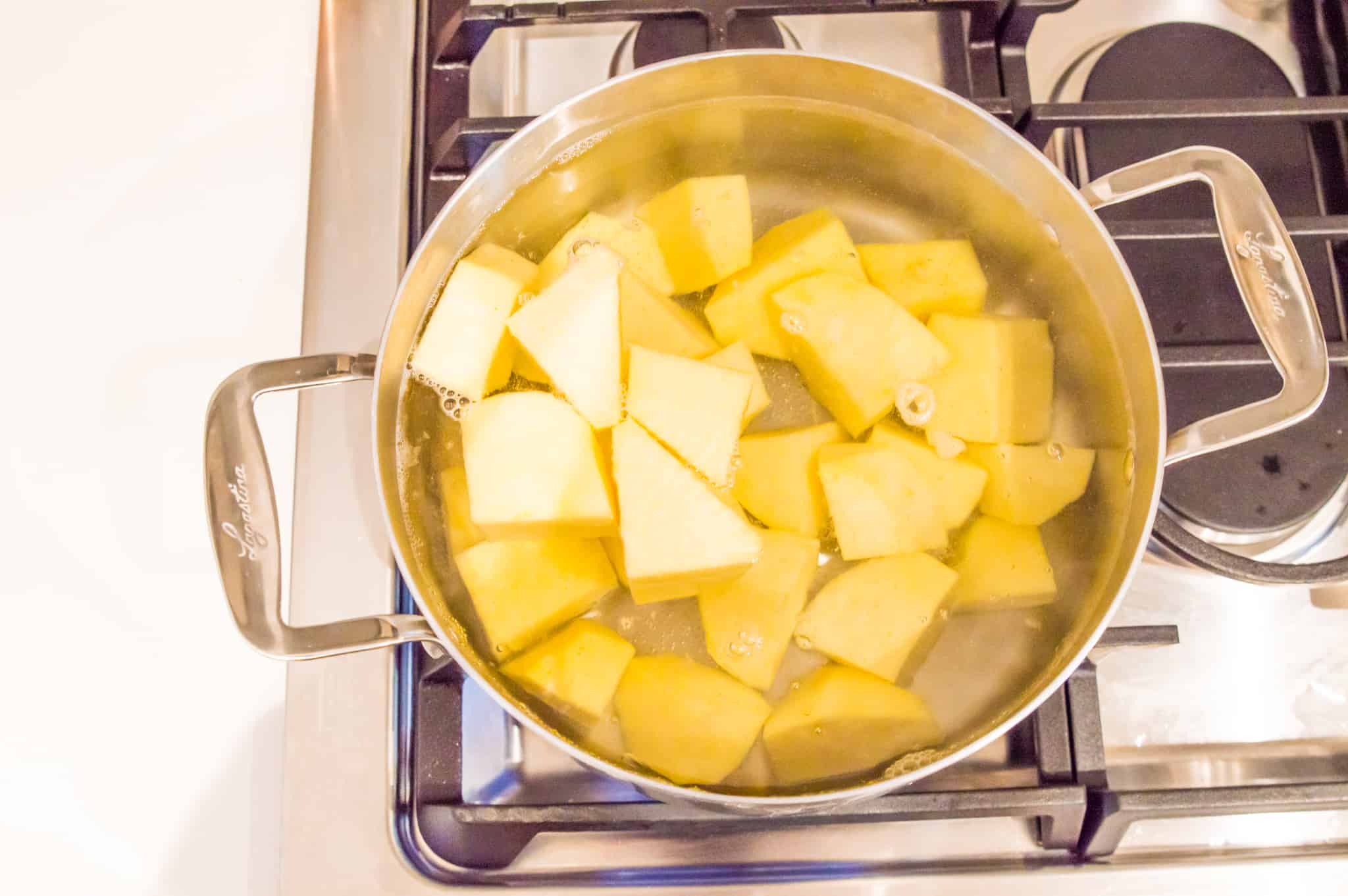 Peeled and chopped turnips in a pot of water on the stovetop.