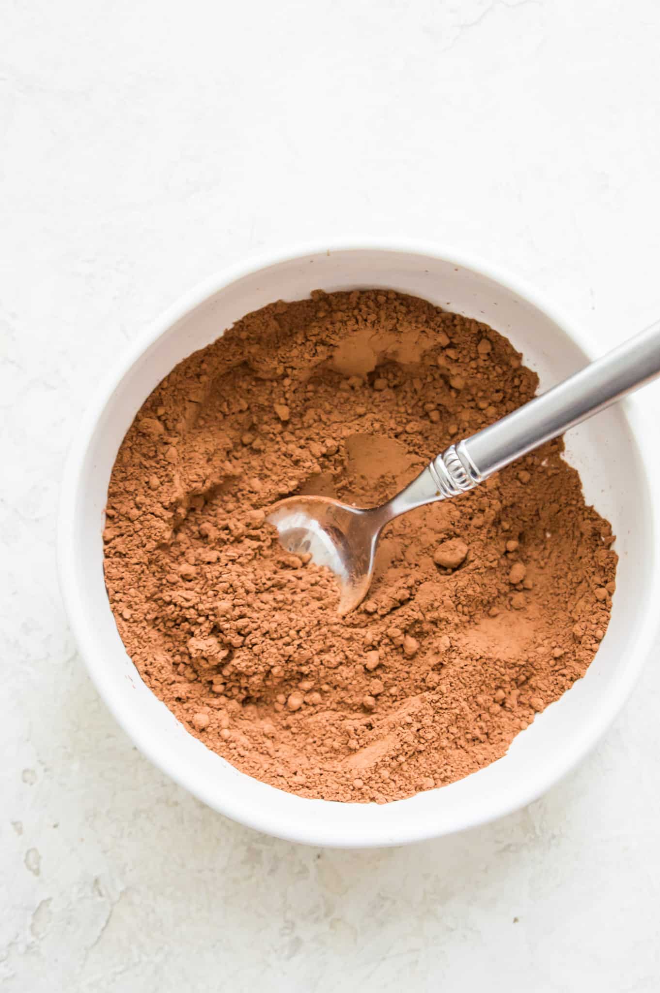 Hot chocolate powder mix in a bowl with a spoon.