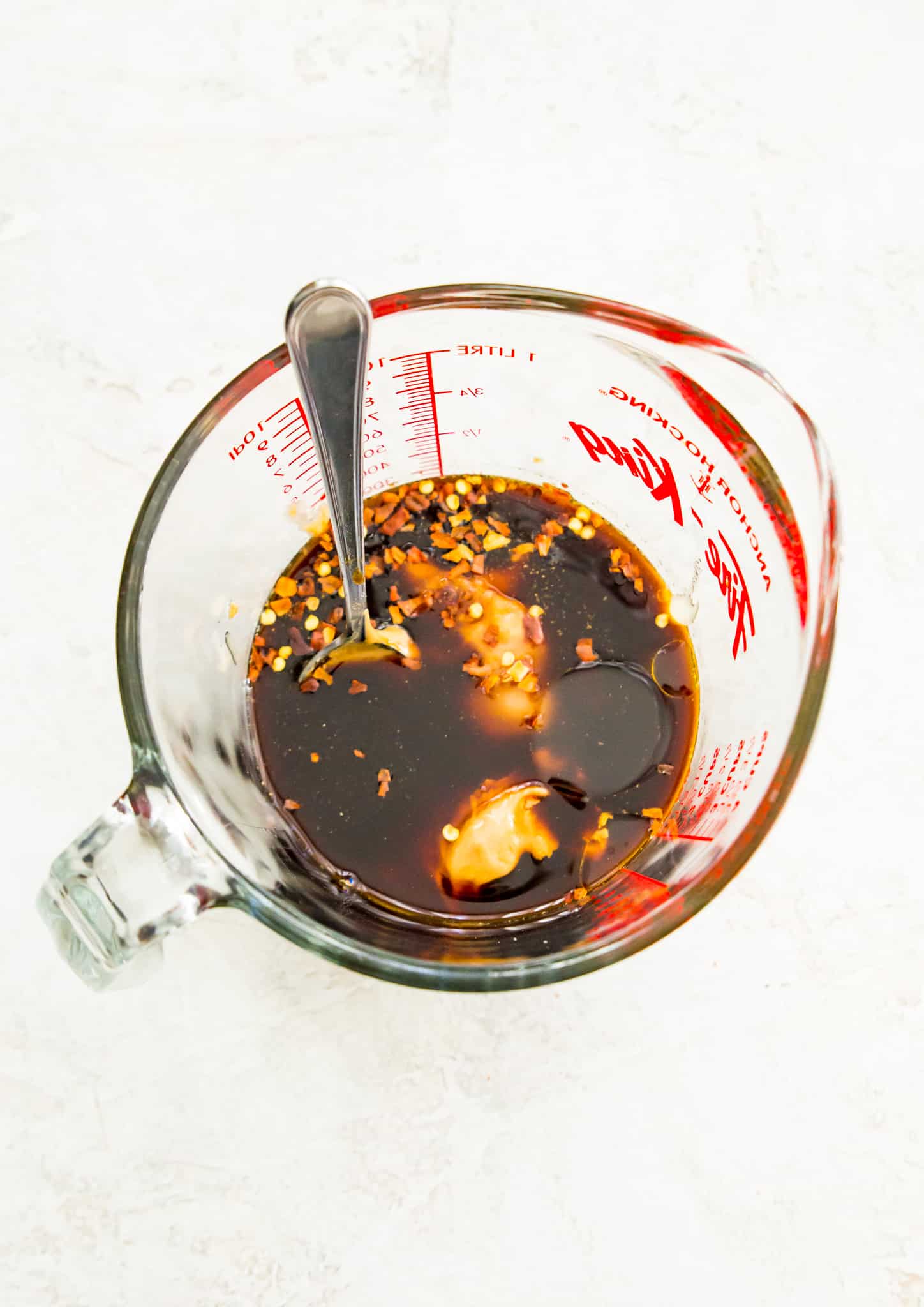 A measuring cup full of pad thai peanut sauce ingredients 