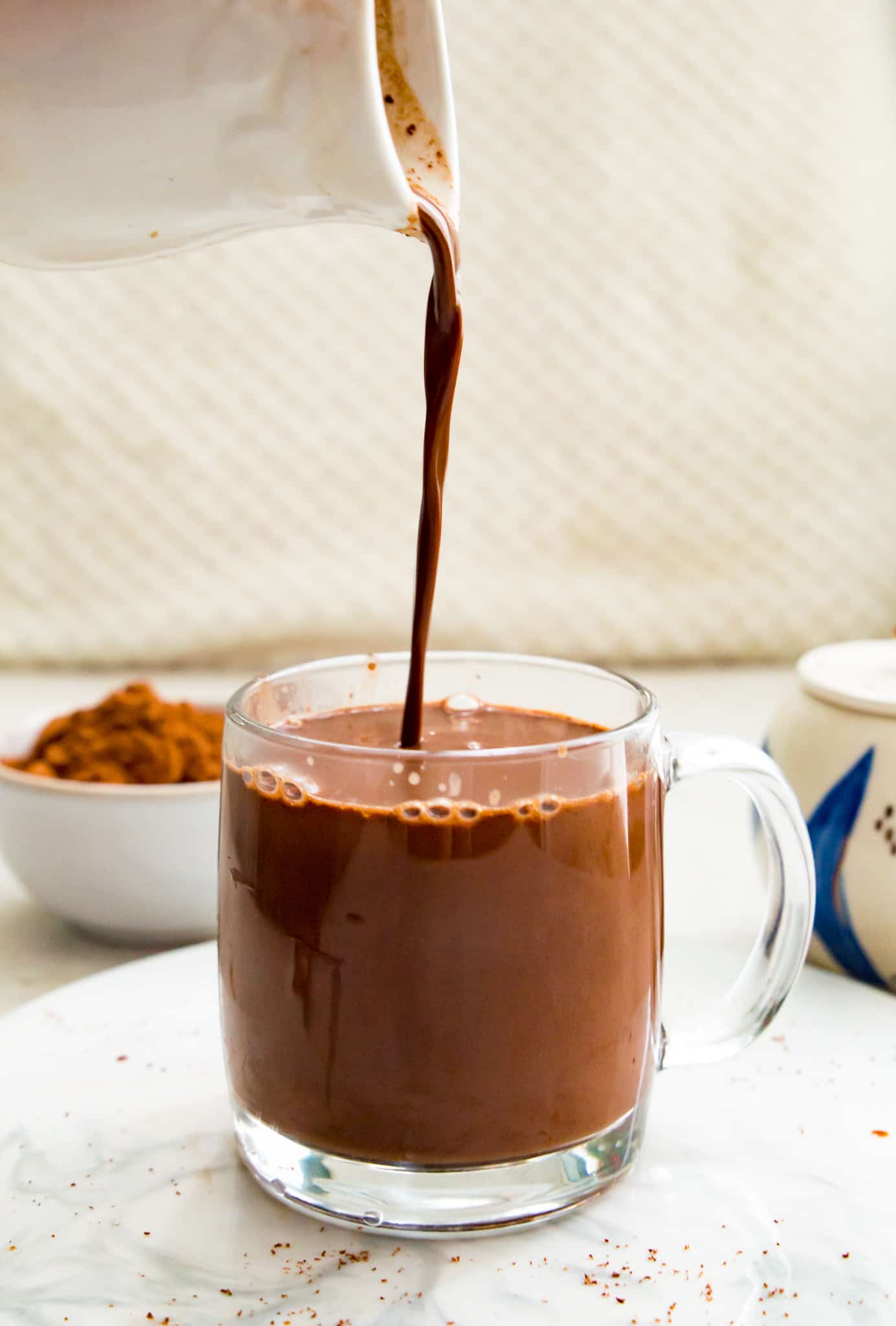 Chocolate Milk is poured into a glass cup on transparent