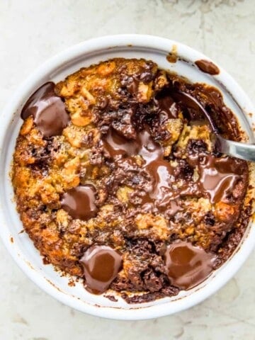 A ramekin filled with baked oats with chocolate chips and a spoon in it.