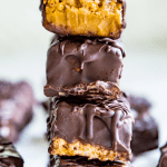 A stack of chocolate peanut butter cereal bars with a bite out of the top one