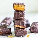 A stack of four chocolate peanut butter cereal bars and the top one has a bite out of it.