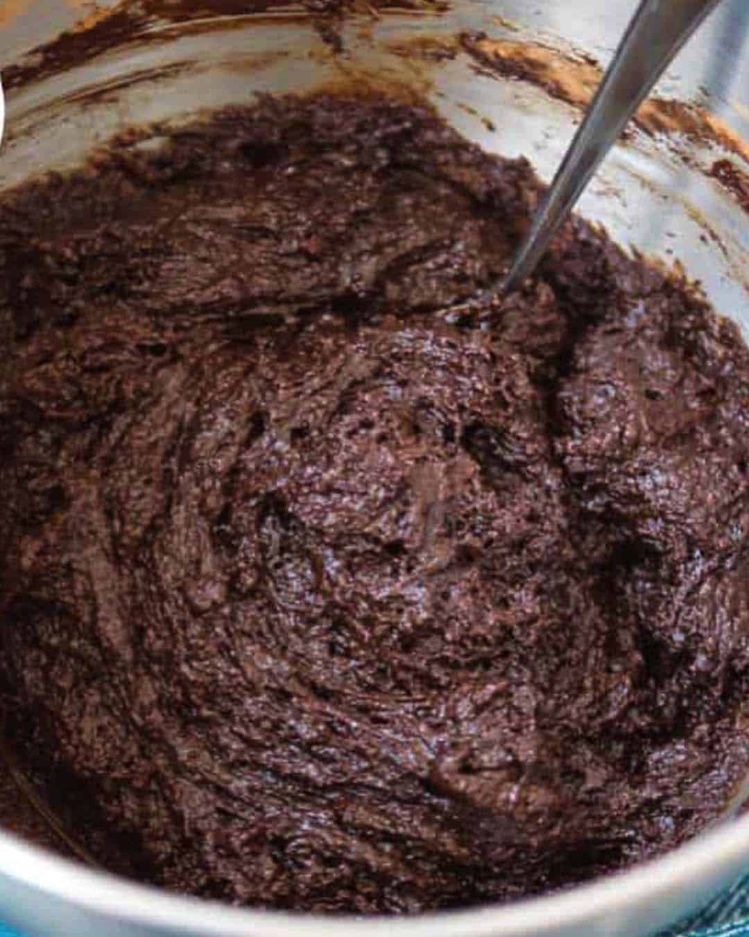 A mixing bowl with brownie batter in it.