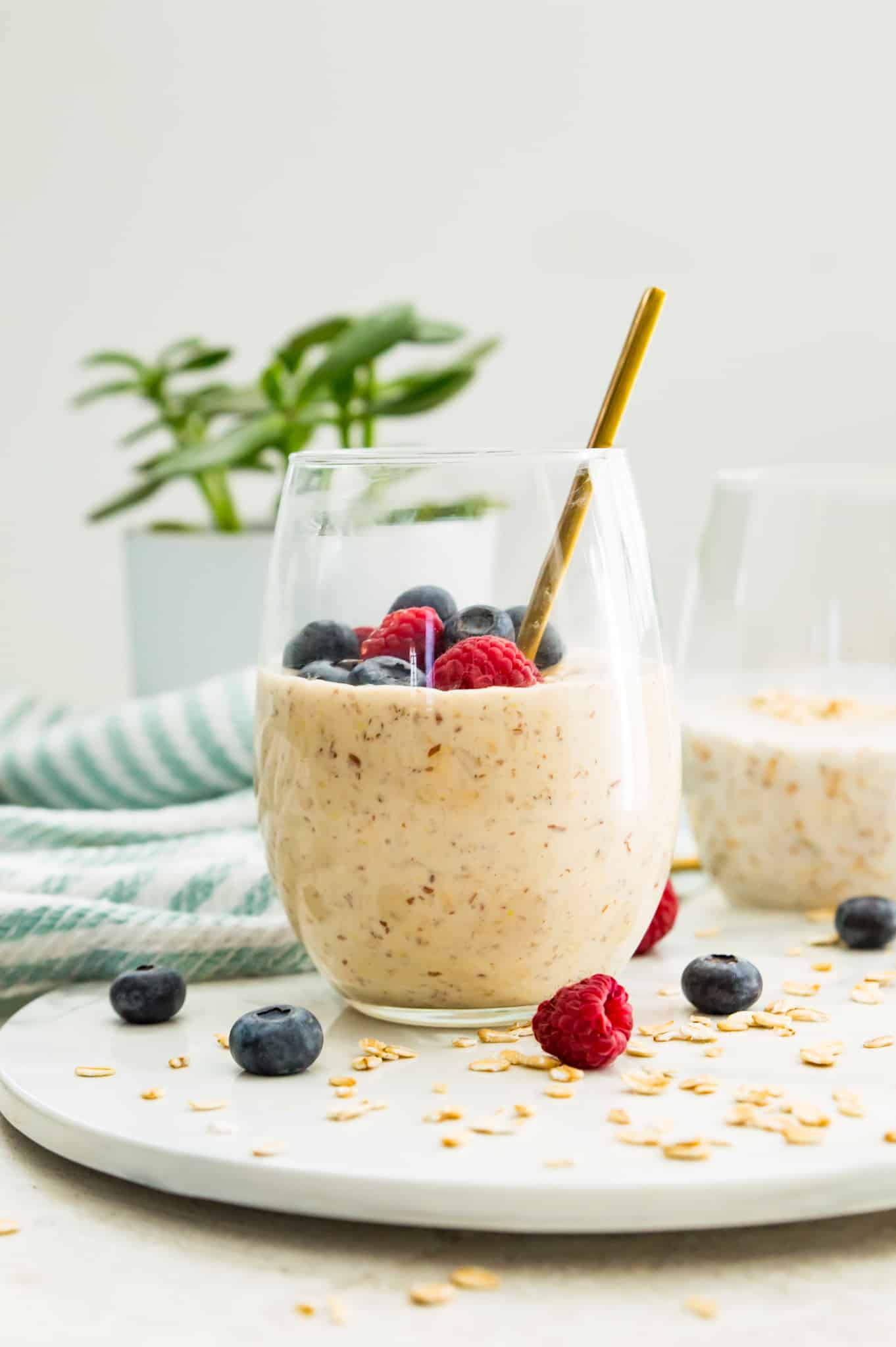 A jar of overnight oats with protein powder topped with blueberries and raspberries.