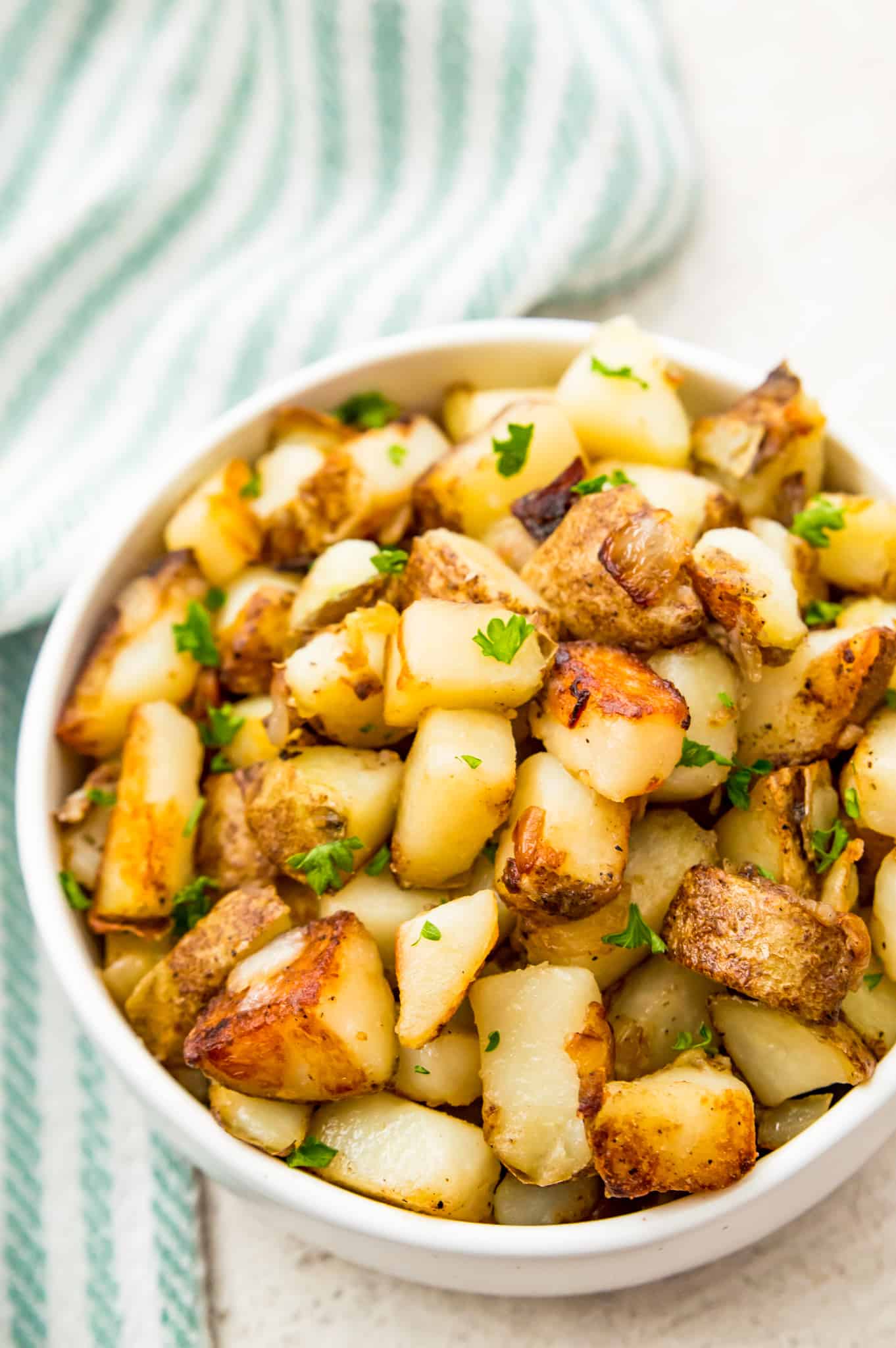 A bowl of cubed, fried potatoes and onions. 