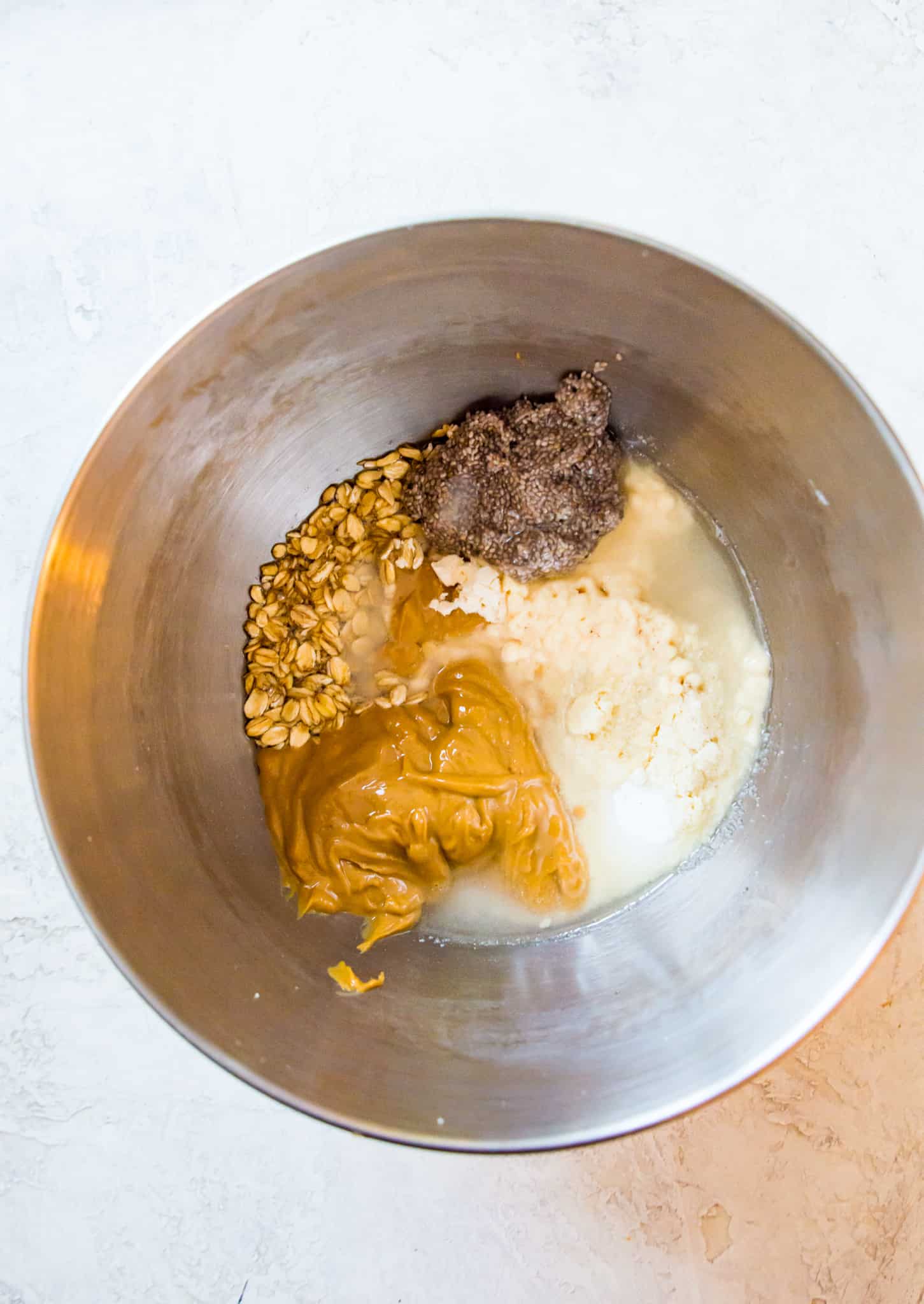 A bowl with peanut butter, flour and maple syrup in it.