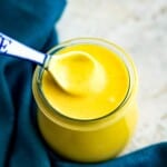 A jar of honey mustard sauce with a spoon in it.