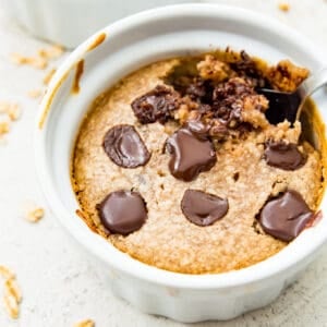 A ramekin filled with baked oats topped with chocolate chips.