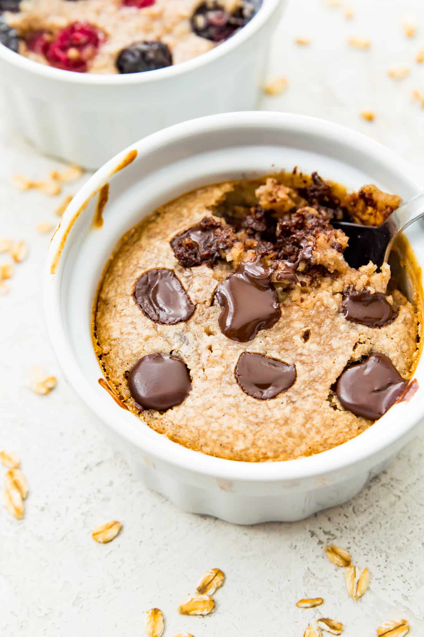 A ramekin filled with protein baked oats topped with melted chocolate. 