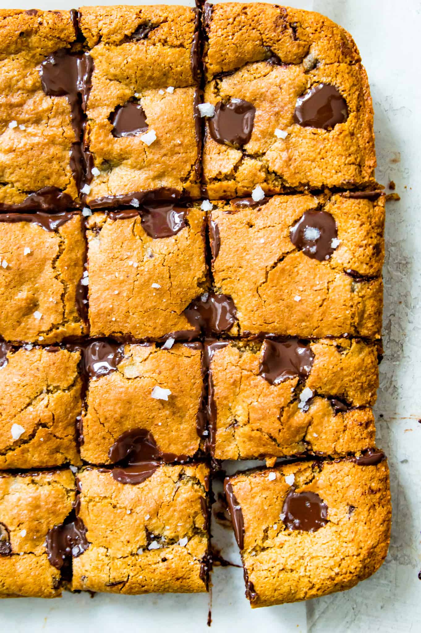 Blondies with chocolate that are cut into pieces and sprinkled with course sea salt. 