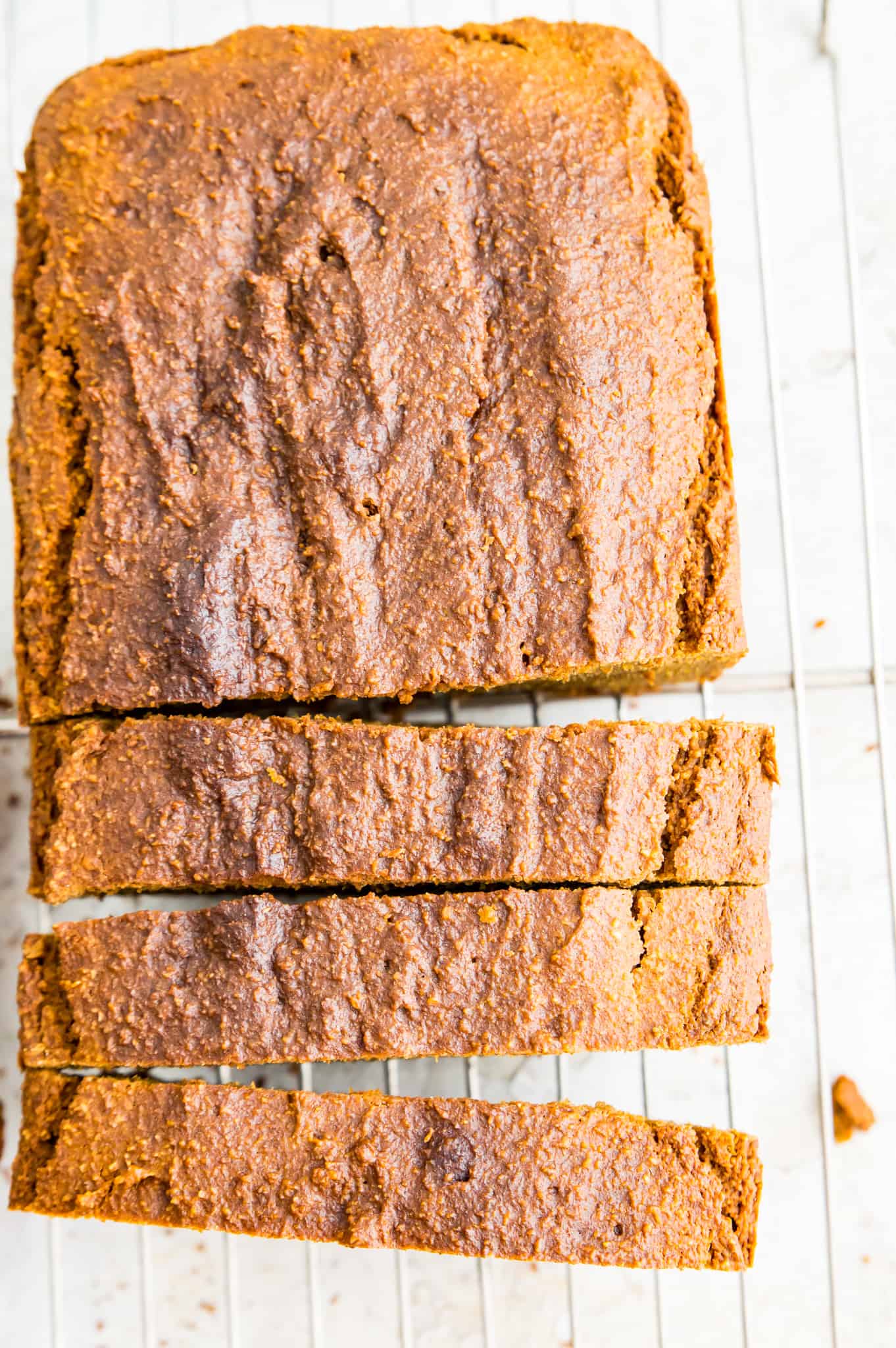 A loaf of avocado bread cut into pieces on a baking rack.