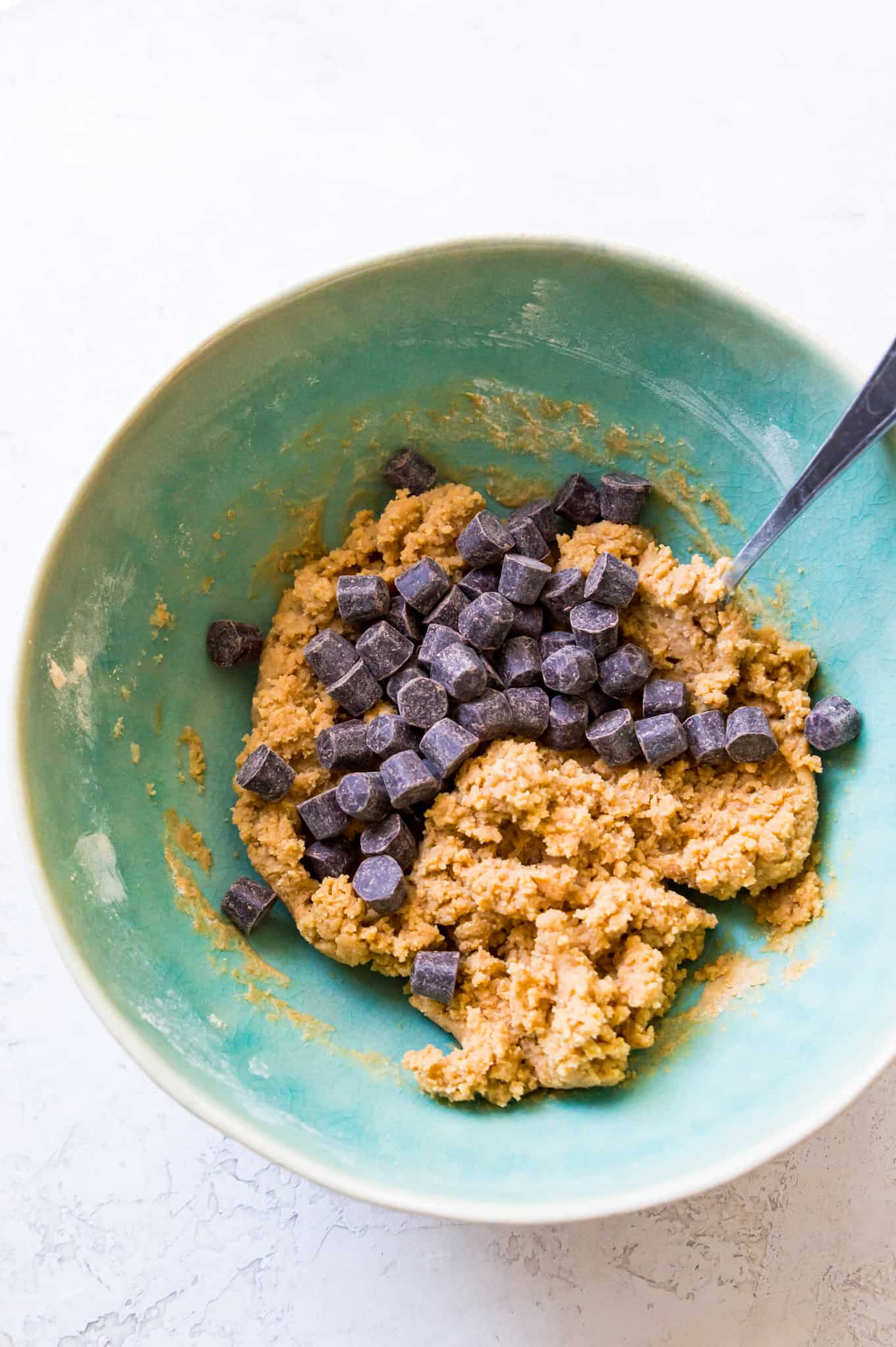 A bowl of edible protein cookie dough with chocolate chips. 