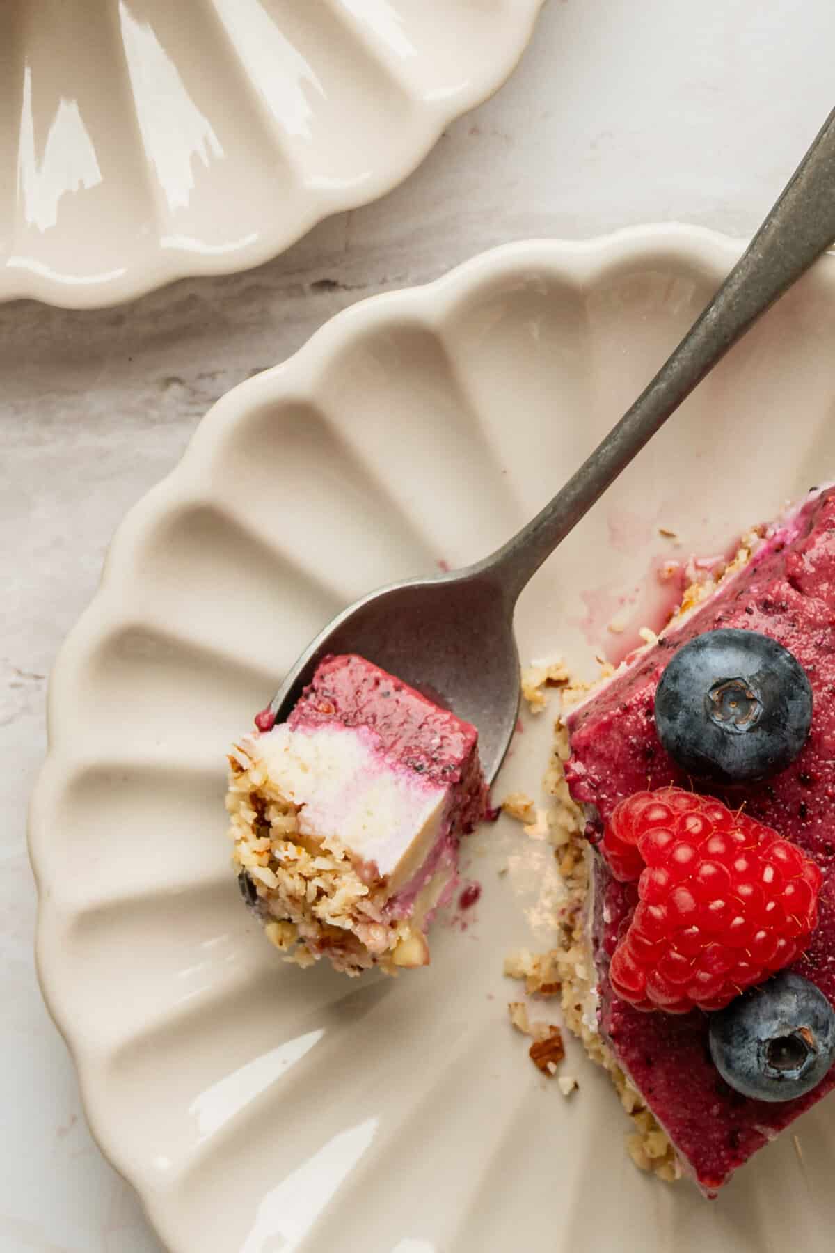 A piece of vegan berry cheesecake on a fork.