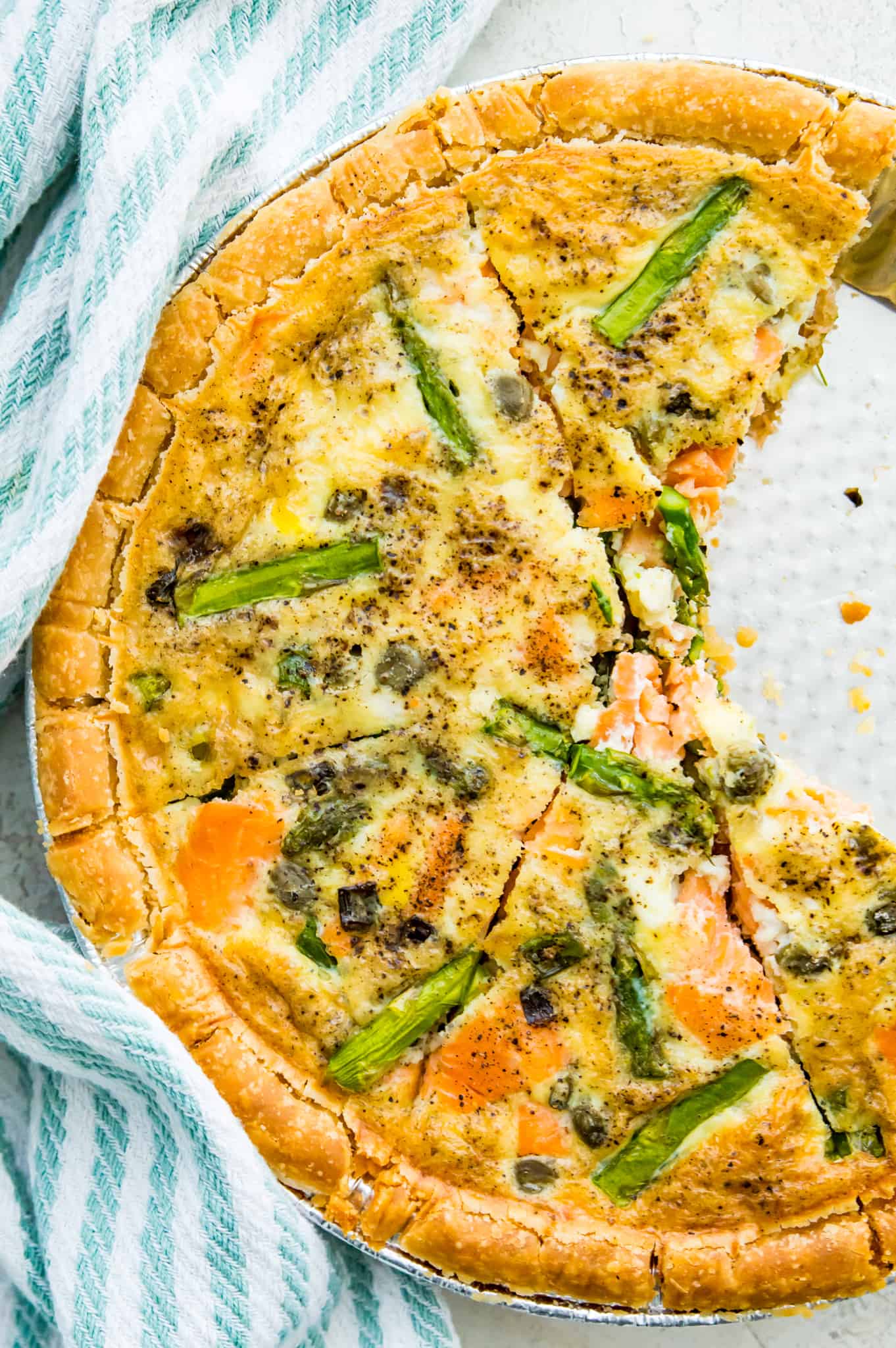 A sliced gluten free quiche in a pie pan on a table. 