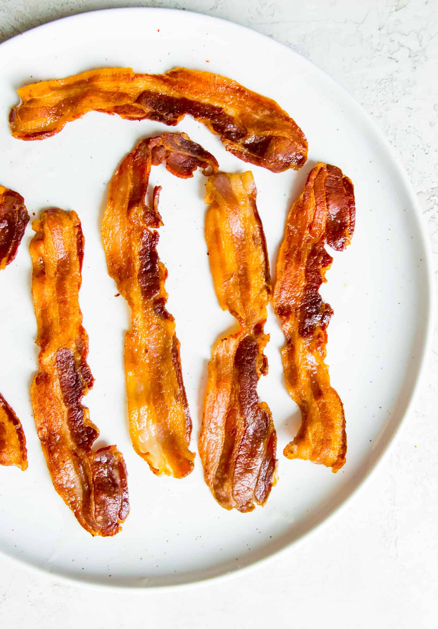 Strips of cooked bacon on a plate.
