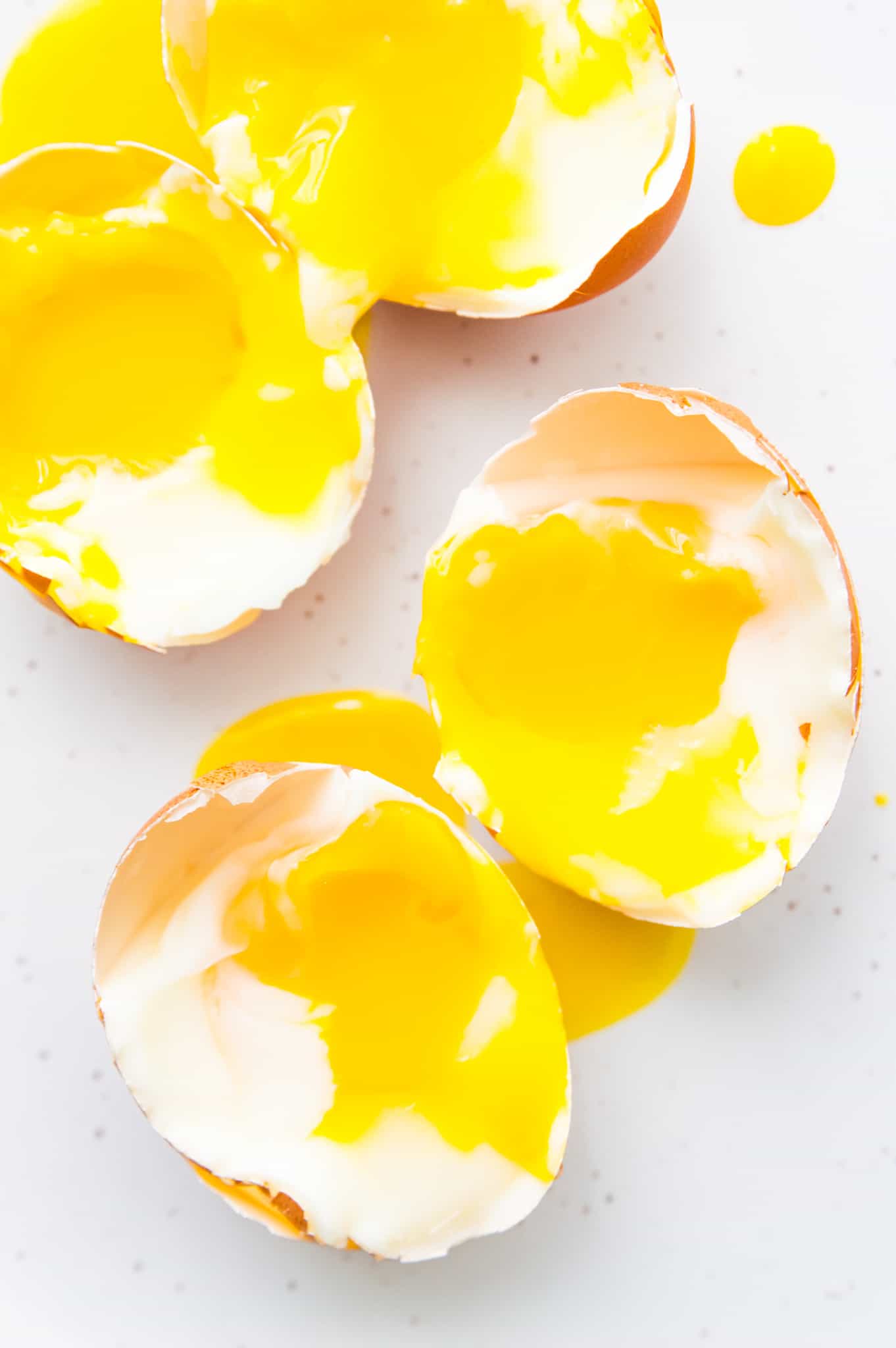 Soft boiled eggs on a white plate still in the shell.