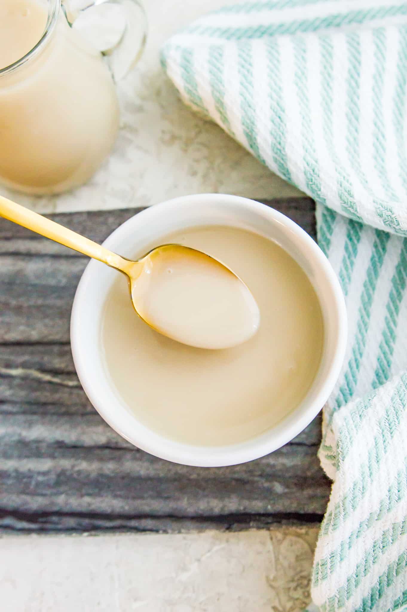 A bowl of dairy free condensed milk with a spoon in it