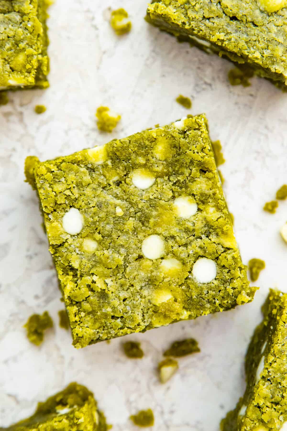 A matcha brownie topped with white chocolate chips on a baking sheet.
