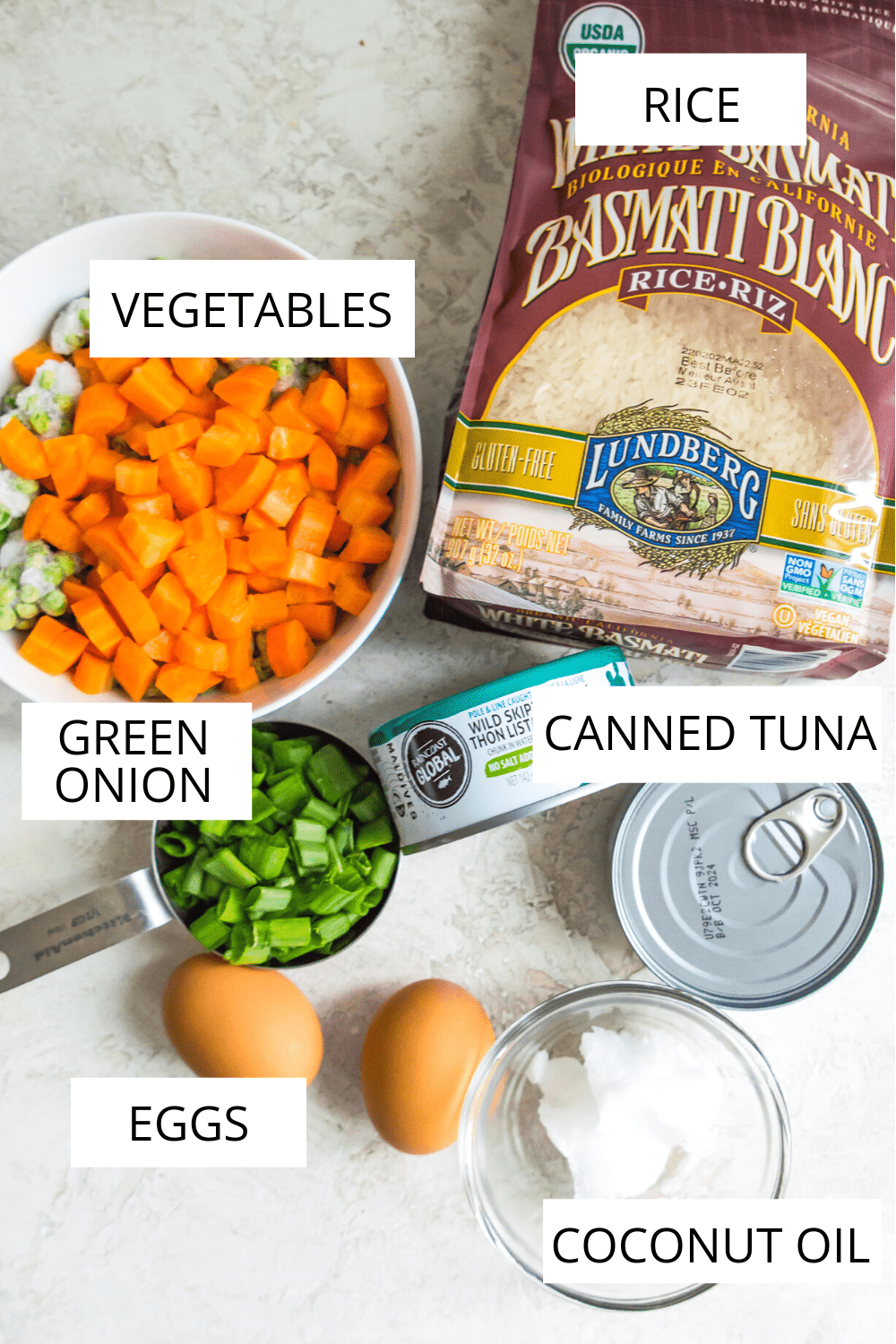 Ingredients needed to make tuna fried rice including vegetates, white rice and canned tuna.