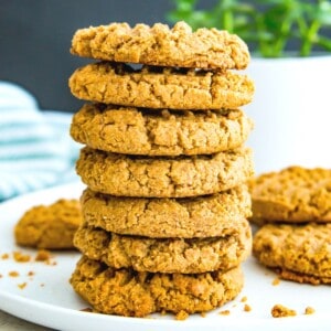 A stack of seven almond flour peanut butter cookies on a plate.