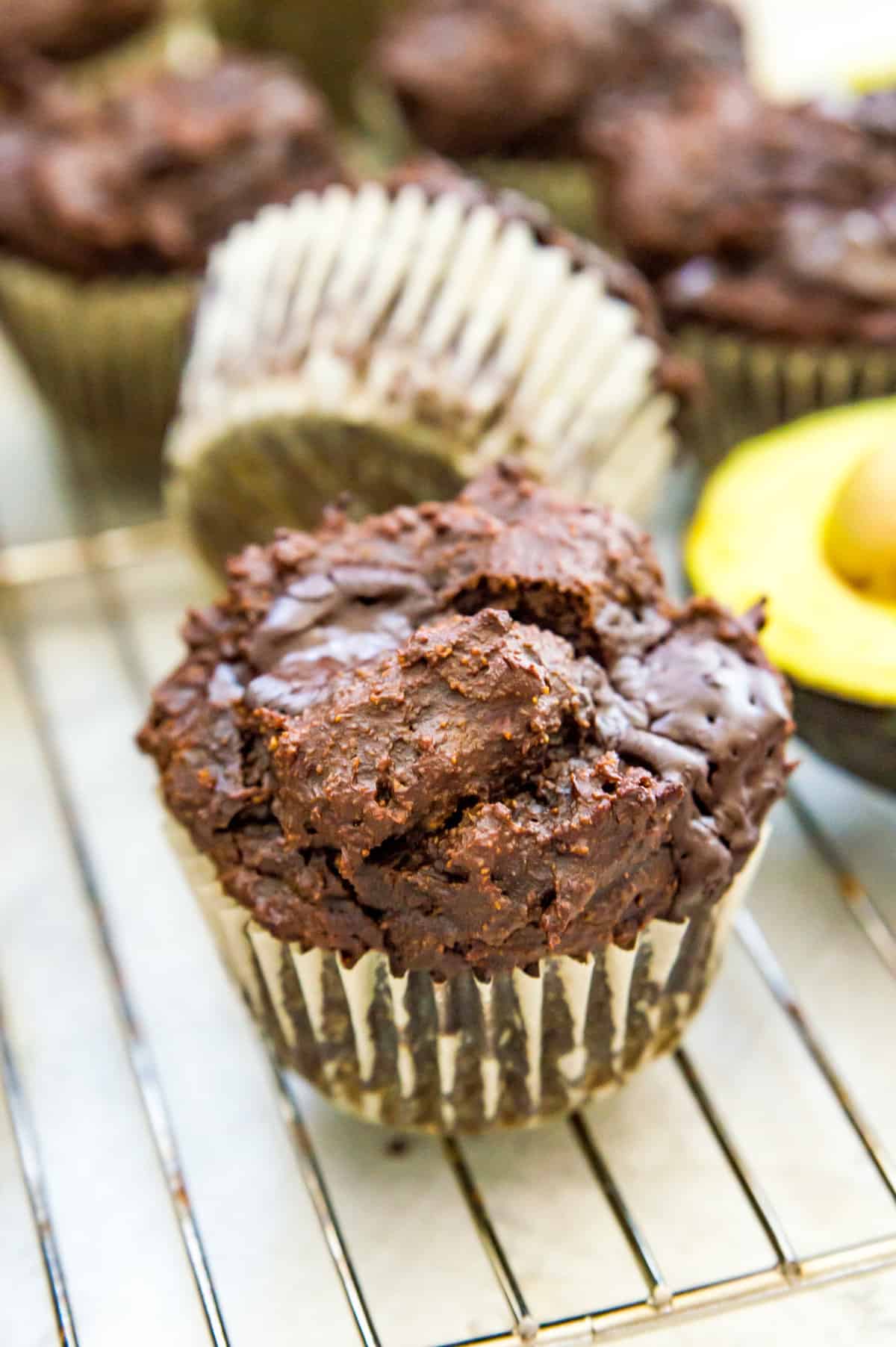 Chocolate avocado muffins on a cooling rack.