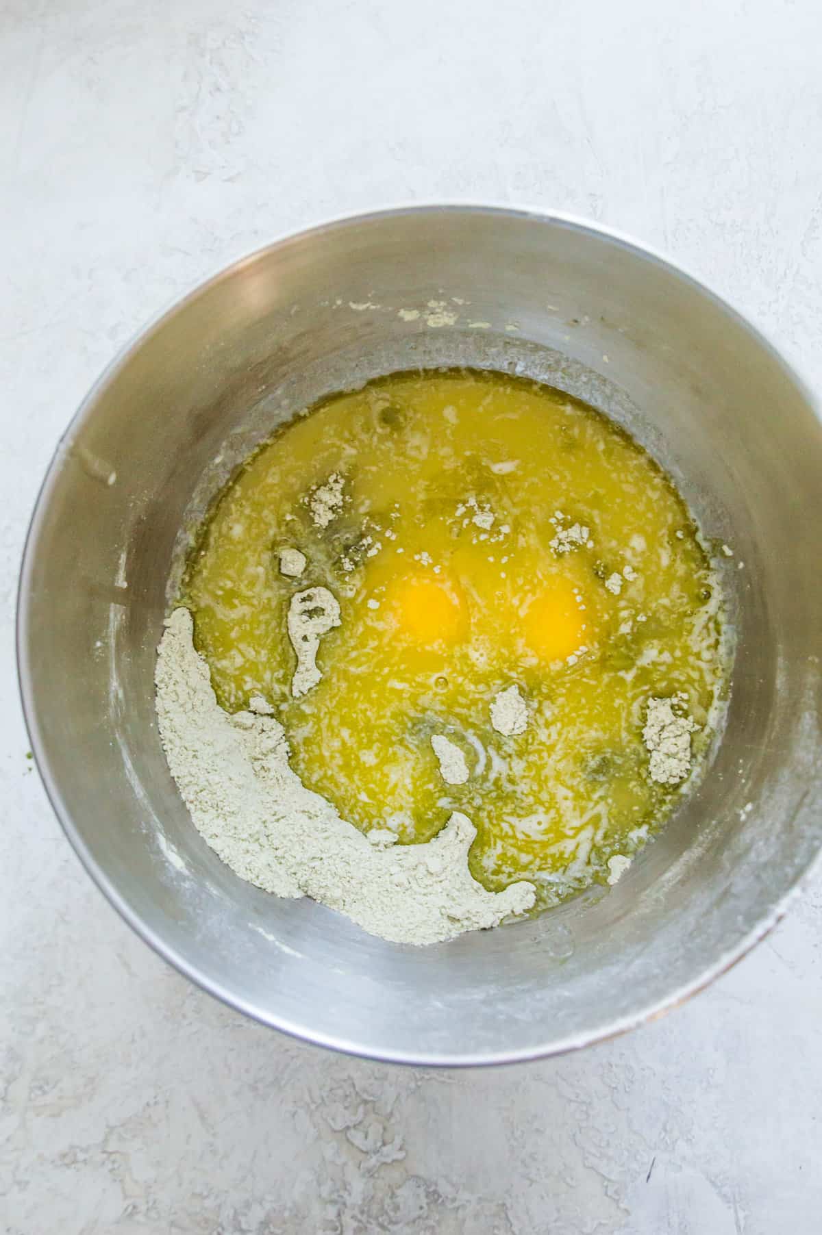 A bowl with eggs and flour in it.