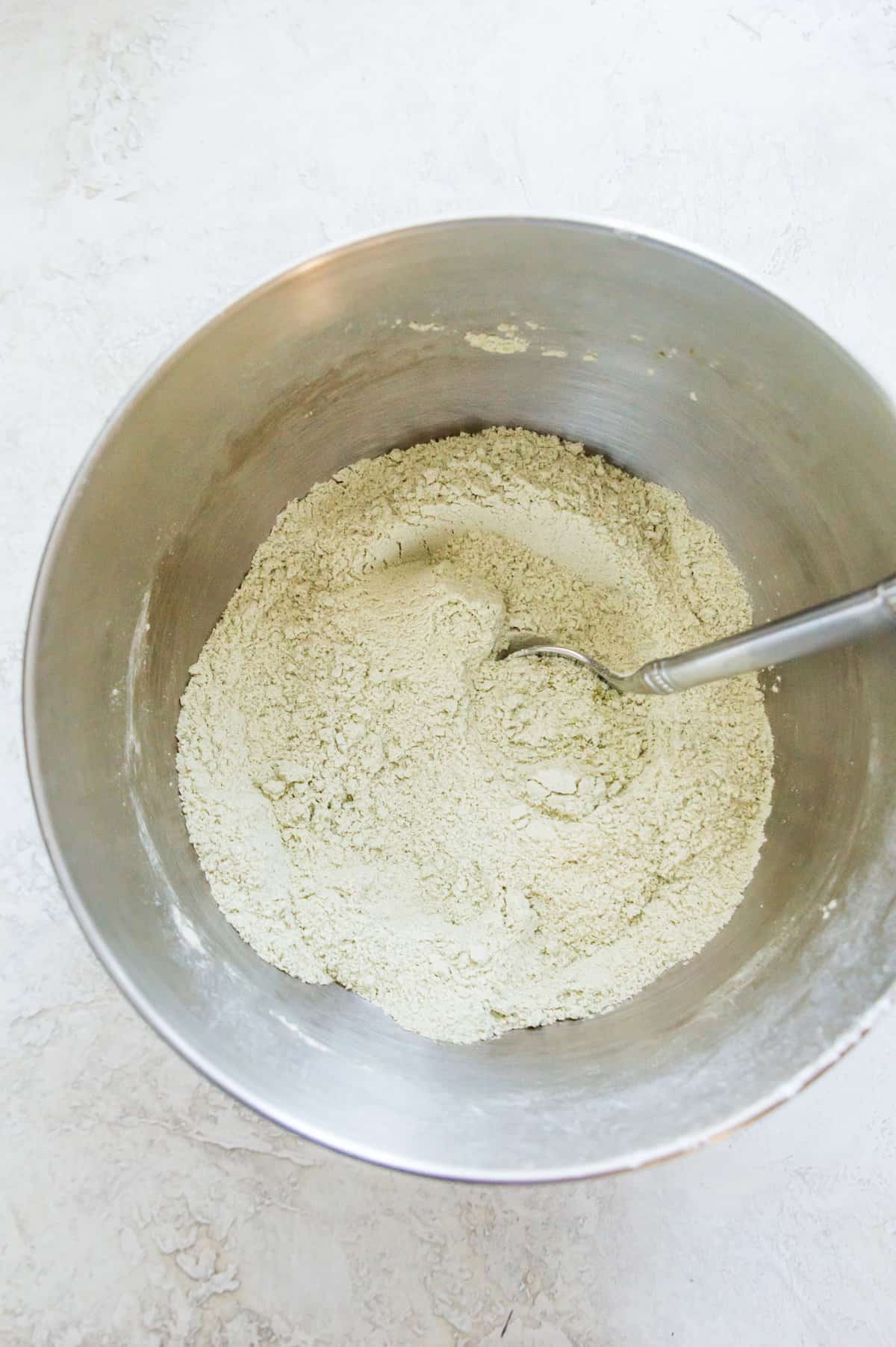 A bowl with flour and matcha powder in it.