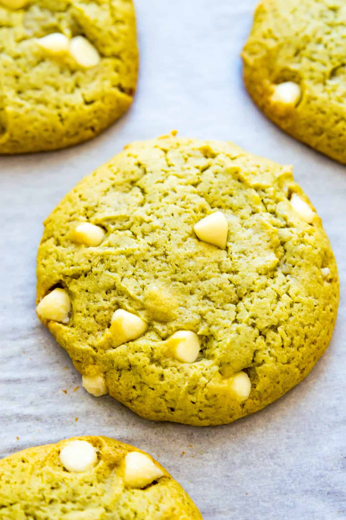 Green tea cookies with white chocolate chips on a baking sheet.