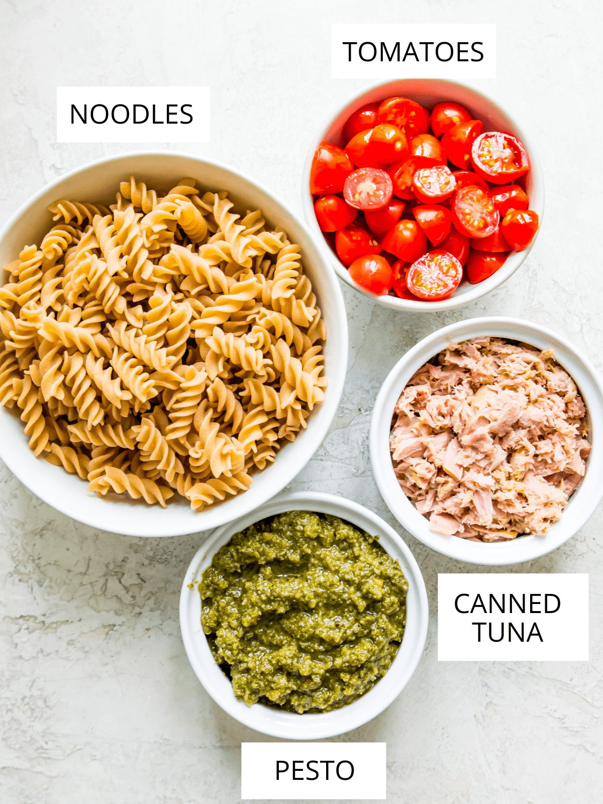 Ingredients needed for making tuna pasta pesto in small bowls.