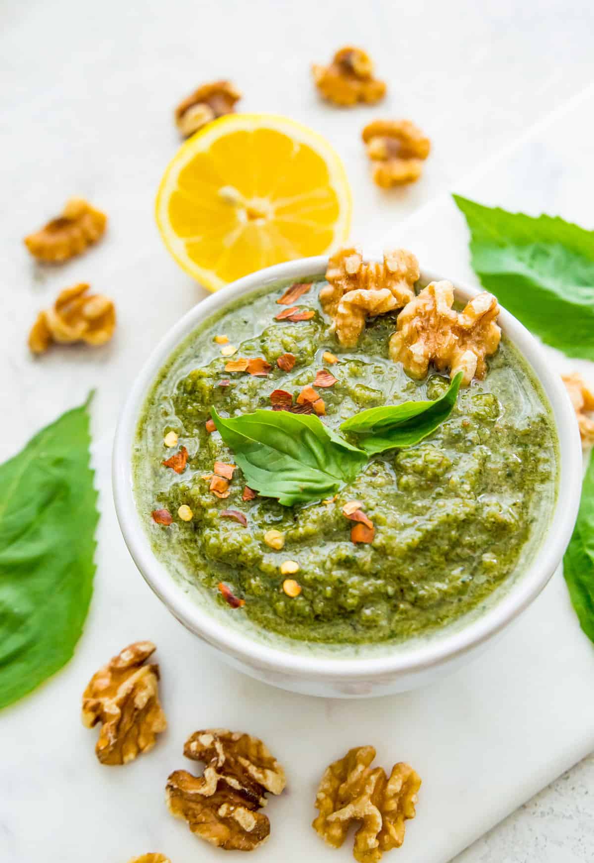 A bowl of dairy free walnut pesto topped with walnuts.