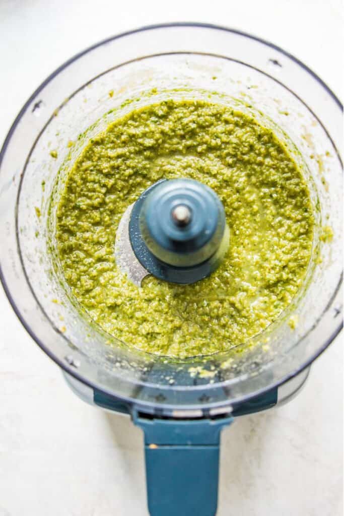 A food processor filled with pesto sauce.