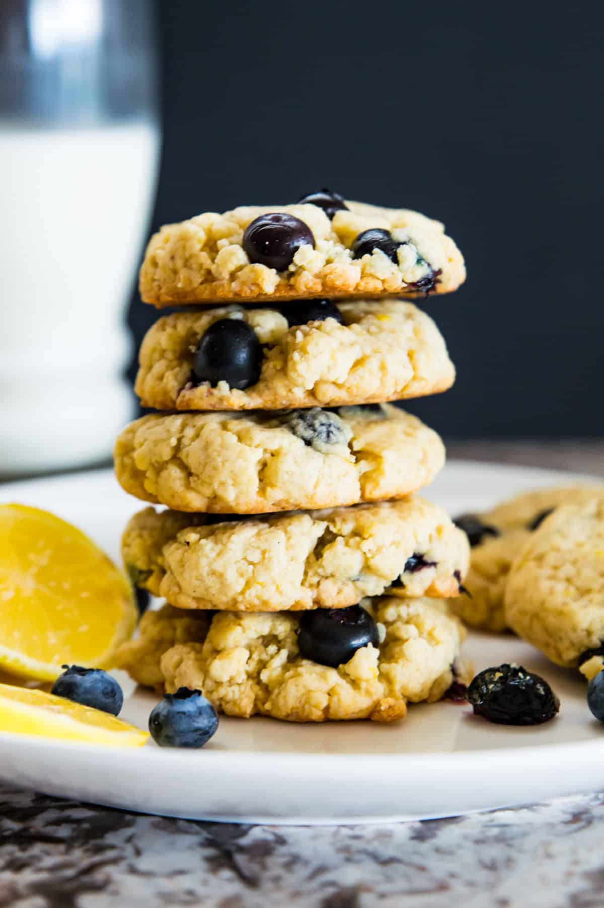 A stack of five lemon blueberry cookies on a plate.