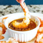 shrimp being dipped into cajun butter sauce