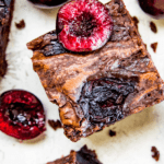 cherry brownies cut into pieces with fresh cherries on top
