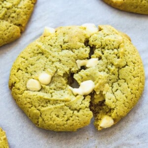 A matcha cookie with white chocolate chips in it being pulled apart.