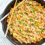 A pan filled with tuna fried rice with chop sticks on top.