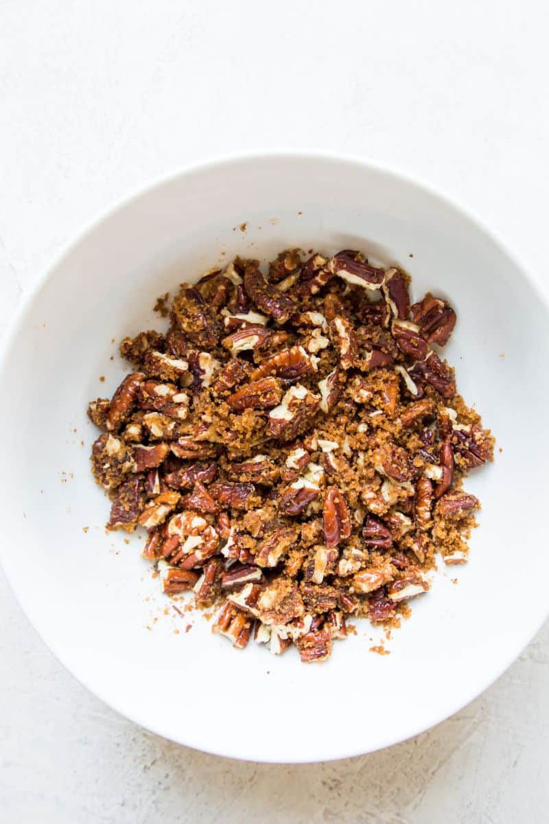 A bowl filled with pecan pieces and sugar.