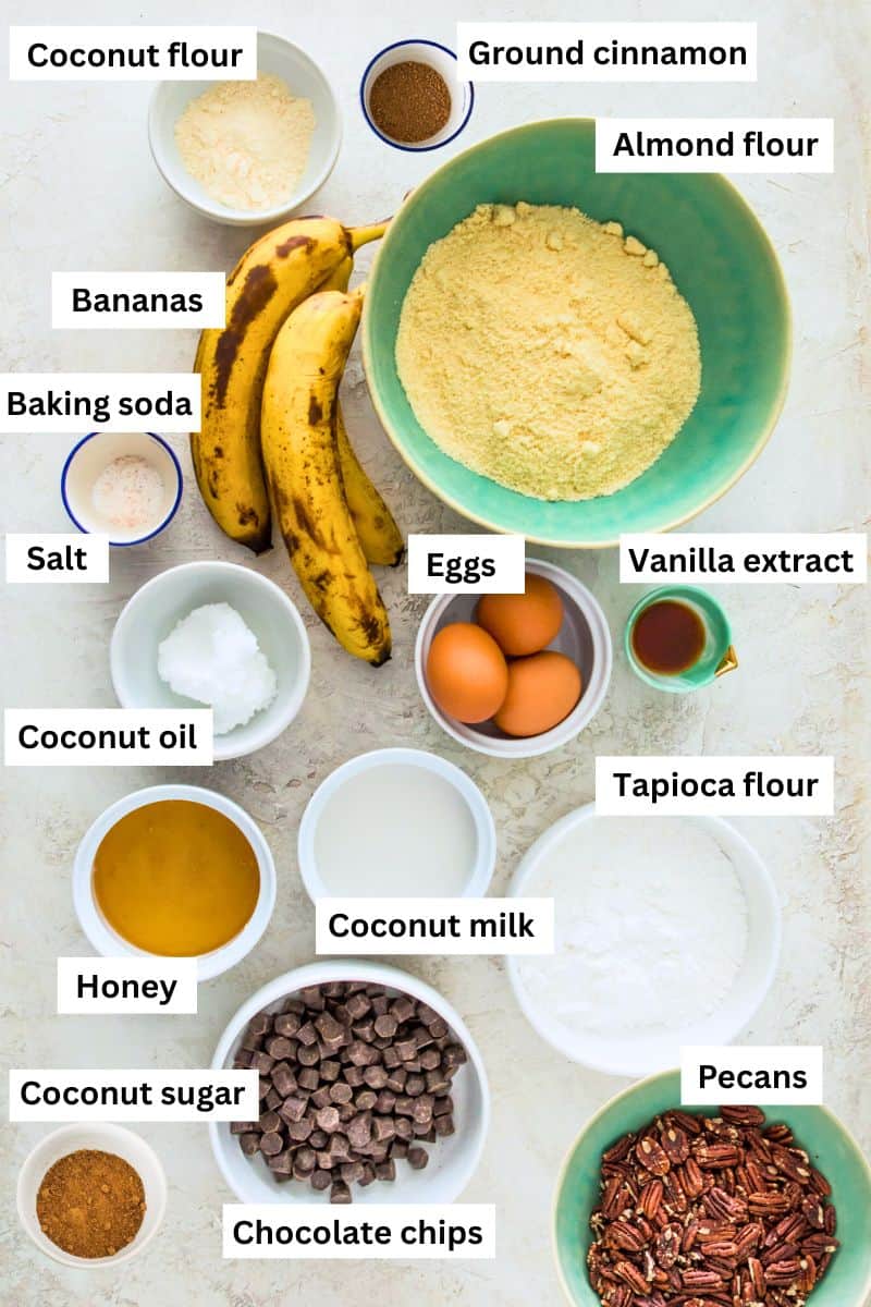 The ingredients for making banana pecan muffins separated into bowls including flour, eggs, bananas, sugar, pecans and cinnamon.