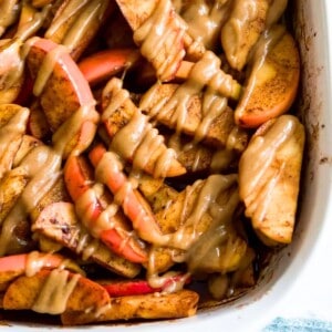 A pan filled with baked apple slices topped with a caramel sauce.