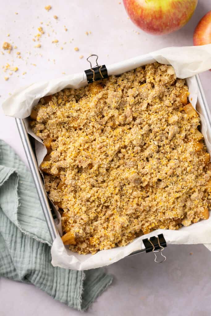 A square baking pan with an apple crumble in it.