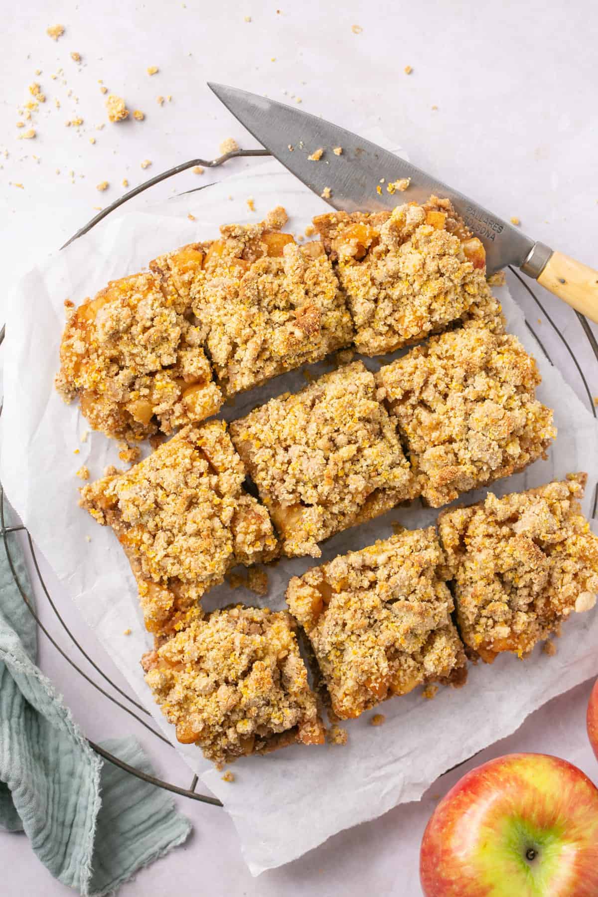 Apple crumble bars cut into pieces, with a knife beside them.