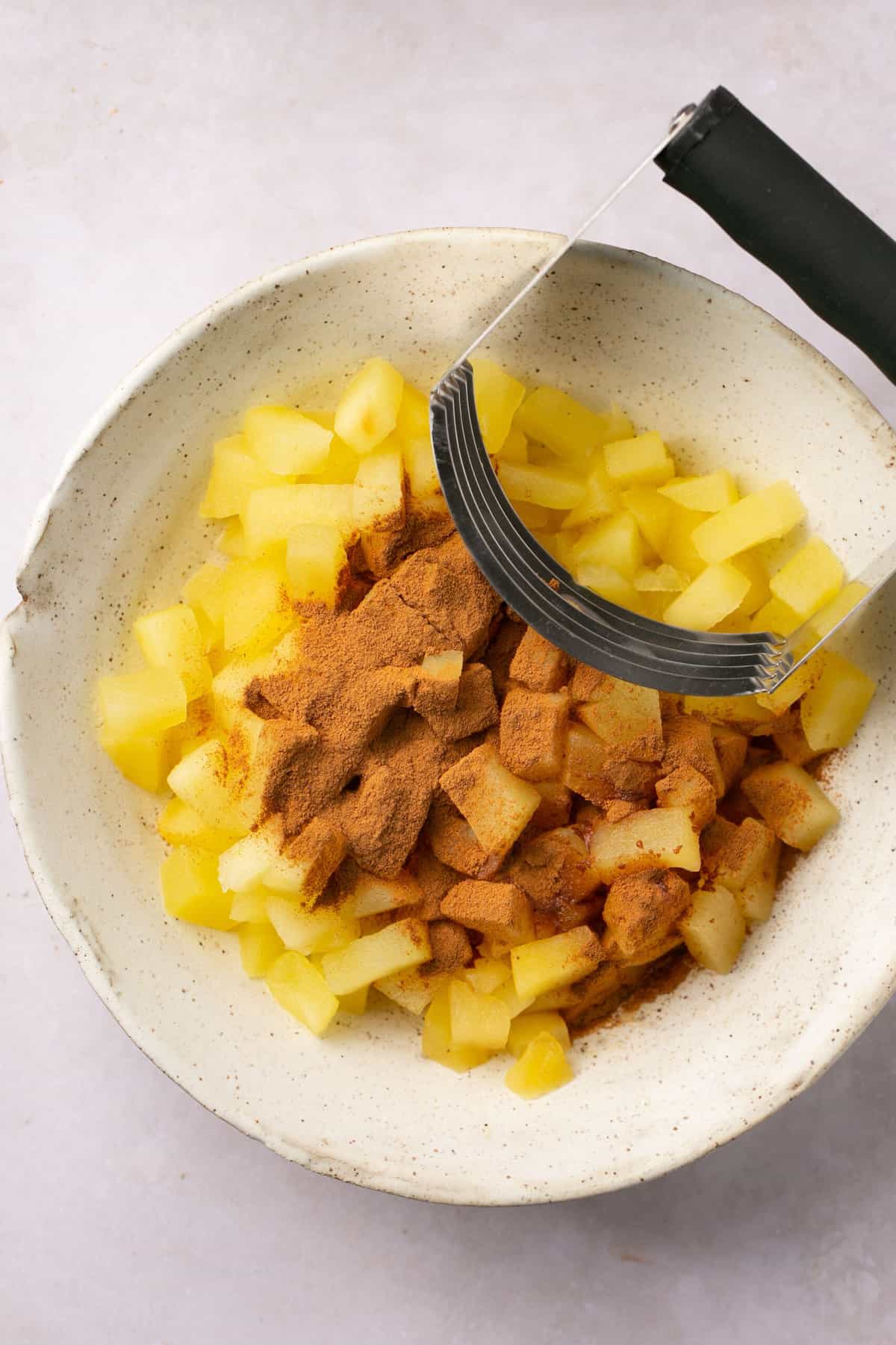 Apple pieces and cinnamon in a large bowl.
