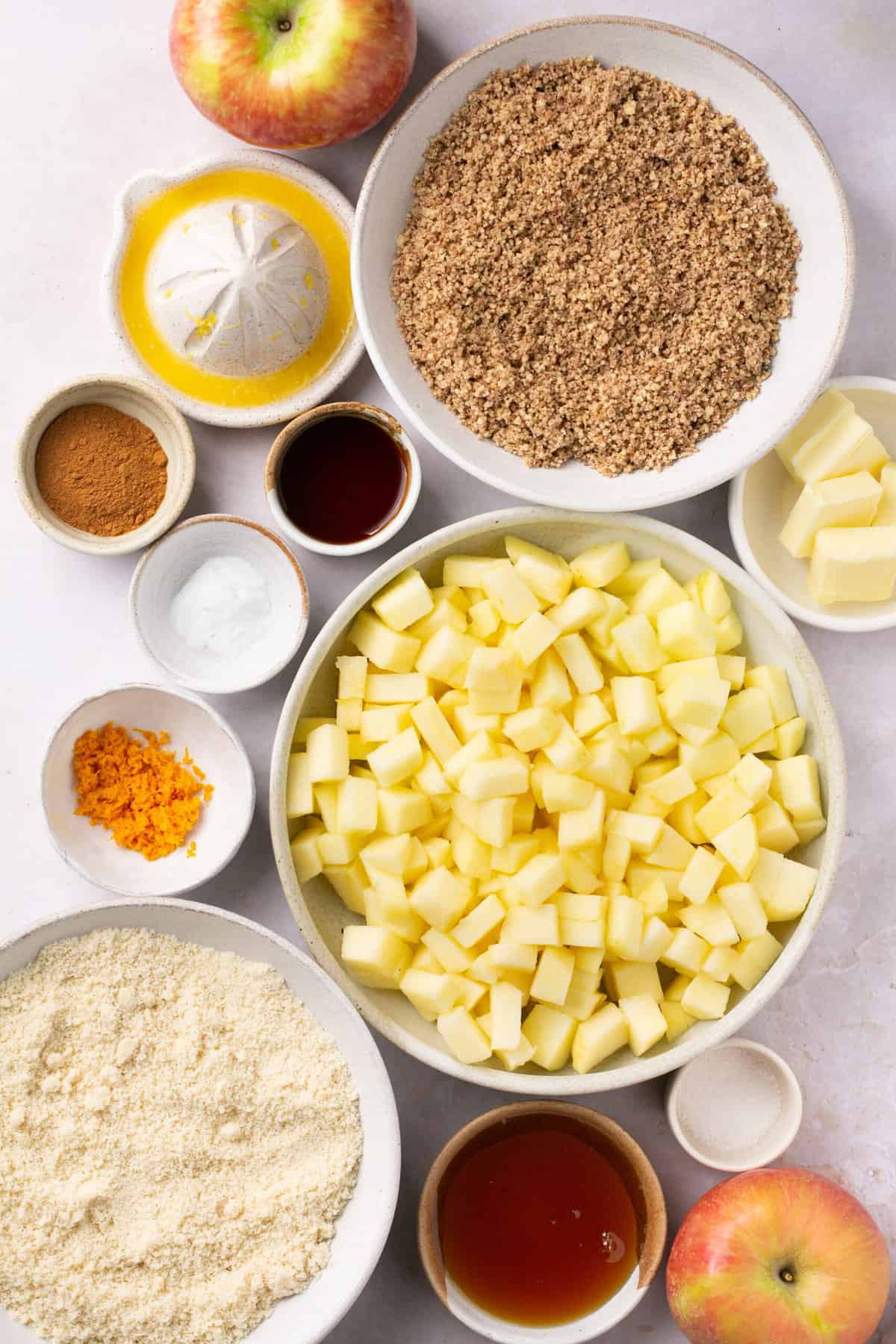 The ingredients needed to make healthy apple bars, separated into small bowls. 