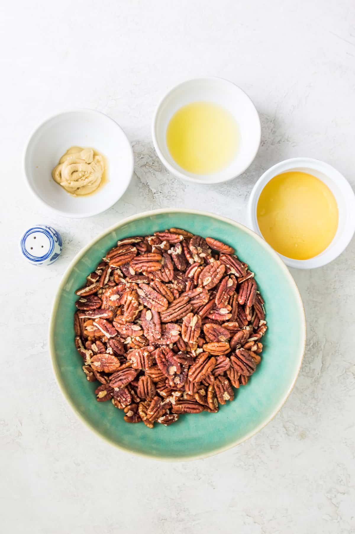 The ingredients for making honey dijon pecans, separated into small bowls. 