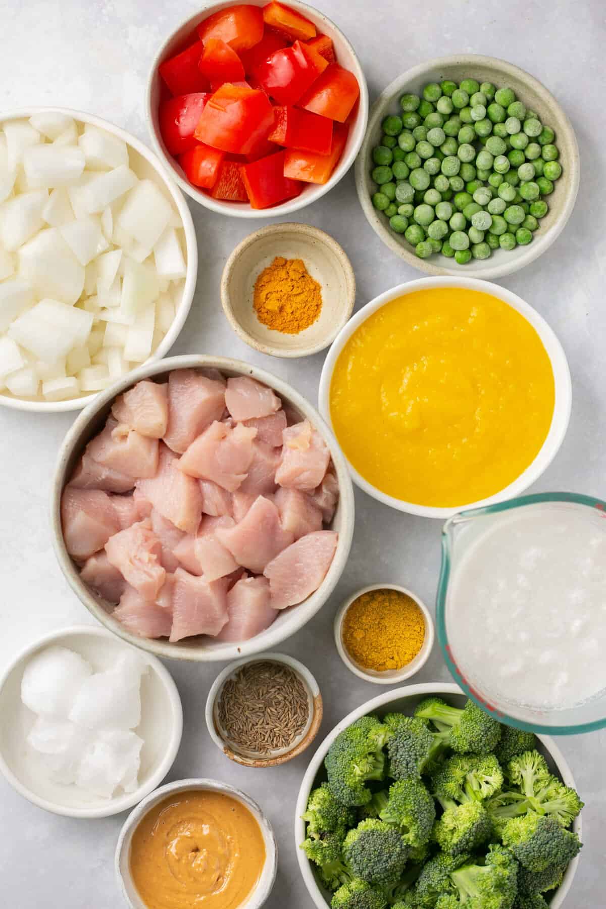 The ingredients needed to make mango chicken curry separated into small bowls. 