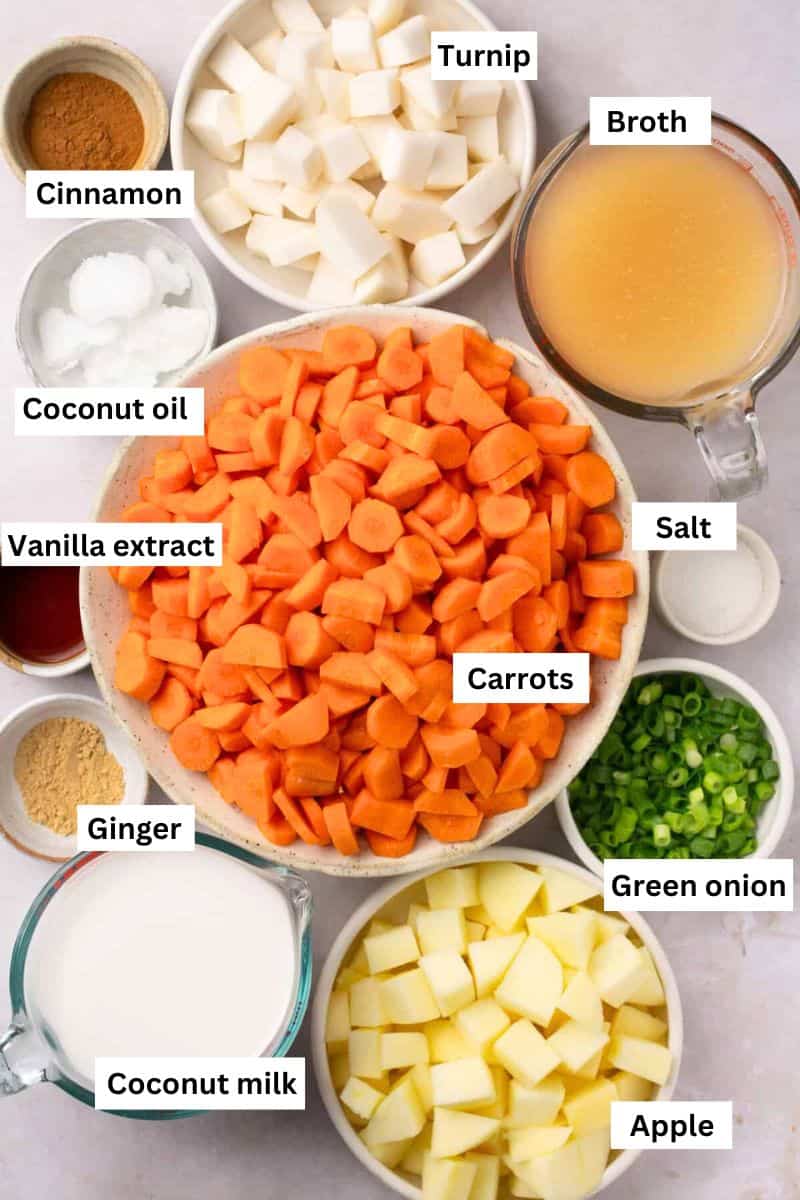 The ingredients needed to make carrot turnip soup separated into bowls including chopped carrots, turnips, broth, coconut milk, cinnamon, apple and coconut oil.