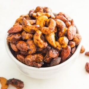 A bowl of glazed curry cashews and almonds.