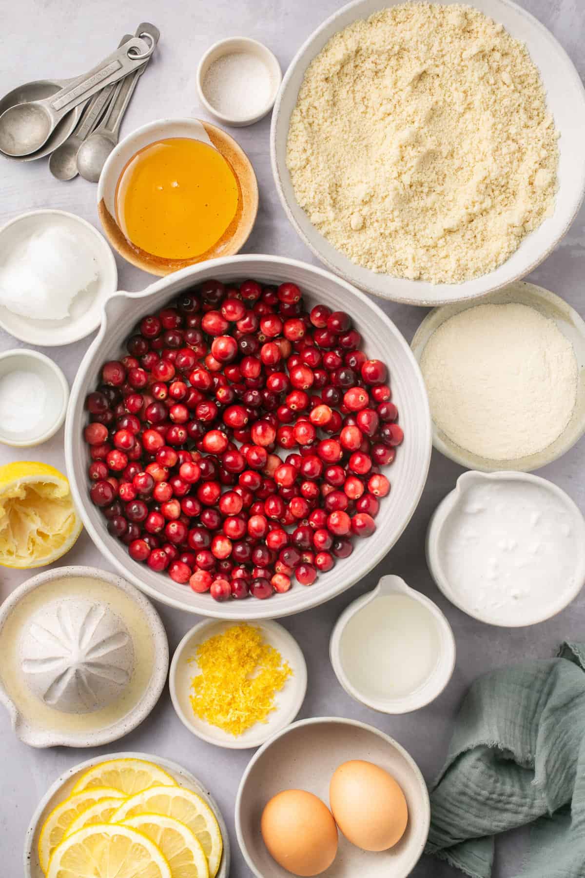 The ingredients needed to make gluten free cranberry lemon bars, separated into bowls. 