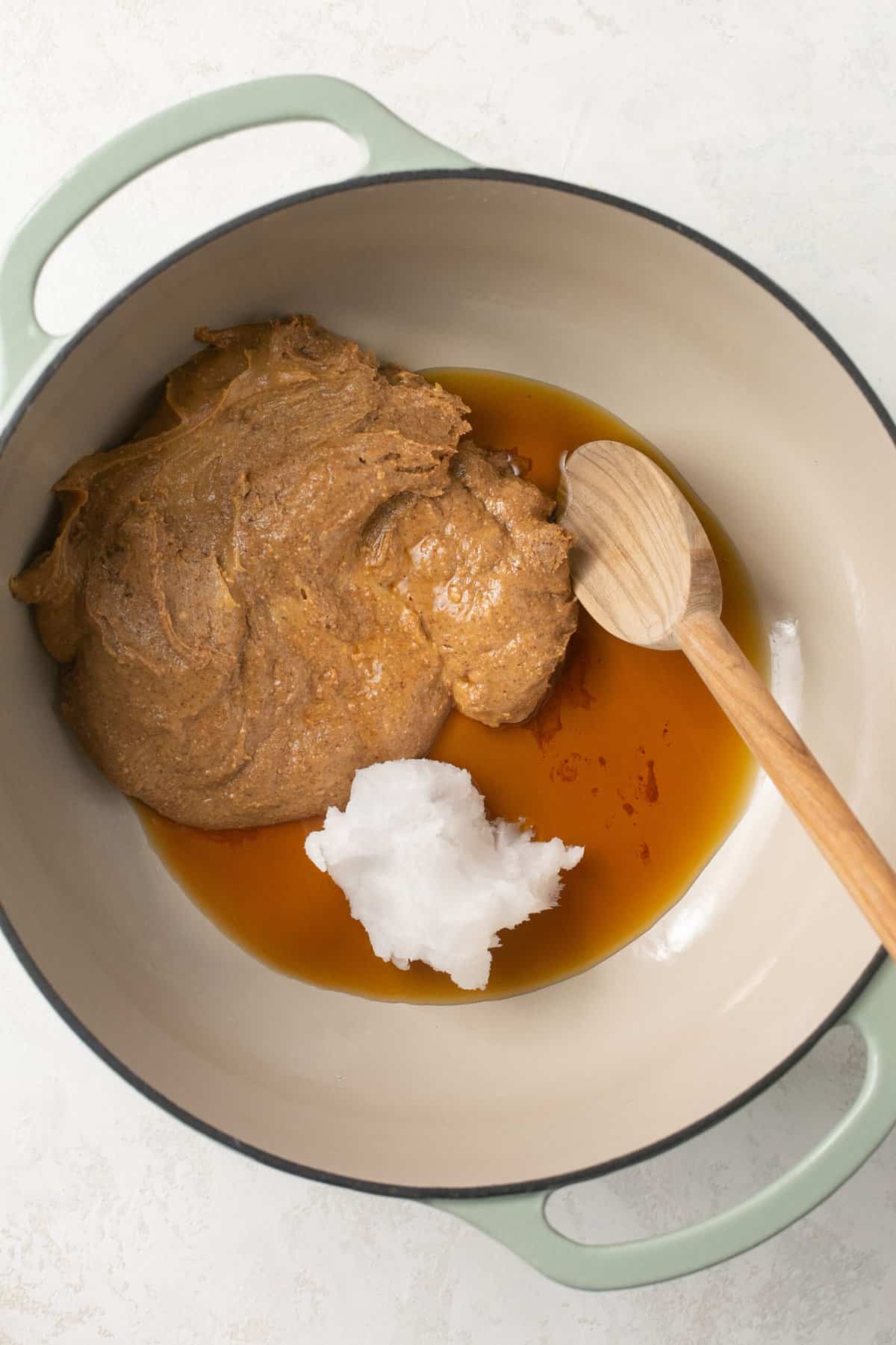 A pot with almond butter, maple syrup and coconut oil in it.